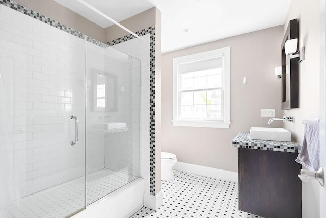 bathroom featuring baseboards, a shower stall, toilet, and vanity