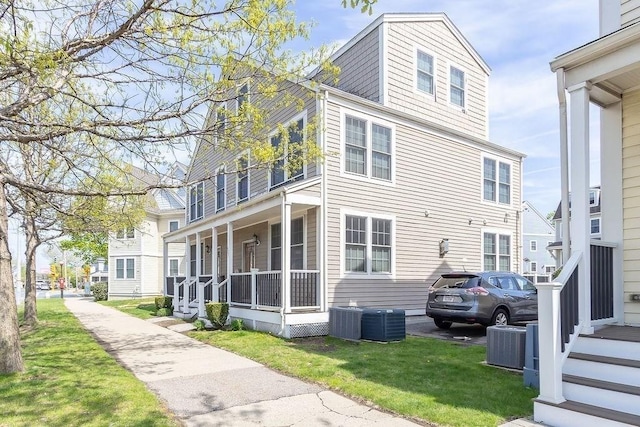 view of home's exterior featuring a lawn, central AC unit, and a porch