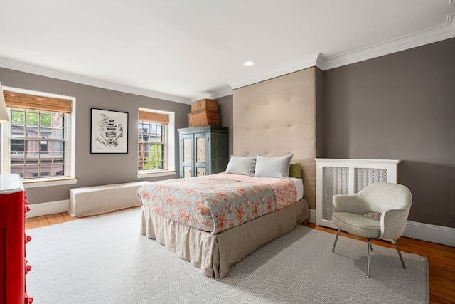 bedroom featuring wood-type flooring, ornamental molding, and multiple windows