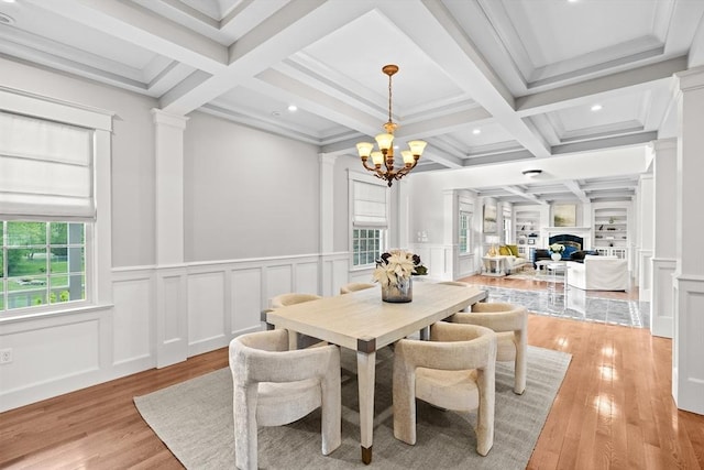 33 Moniz Dr, Westport, MA 02790 - dining space featuring plenty of natural light, a chandelier, ornate columns, a decorative wall, and light wood-type flooring