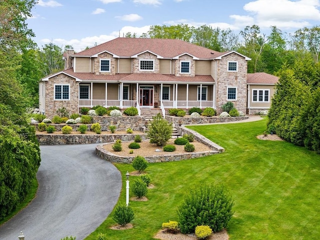 33 Moniz Dr, Westport, MA 02790 - view of front facade with stone siding, a chimney, a porch, and a front lawn