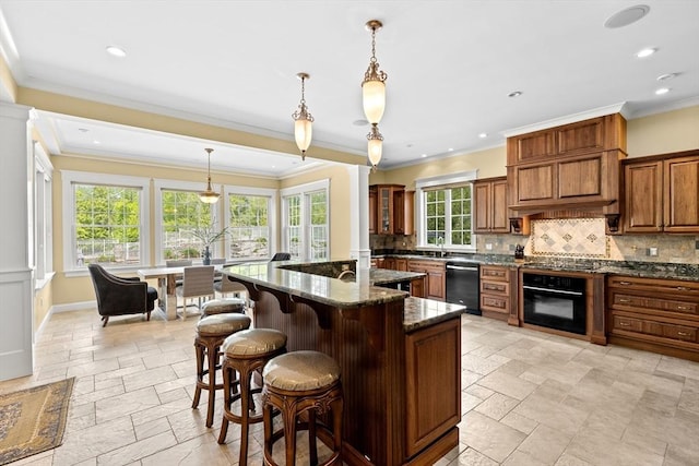 33 Moniz Dr, Westport, MA 02790 - kitchen featuring black appliances, stone tile floors, brown cabinetry, tasteful backsplash, and a breakfast bar area