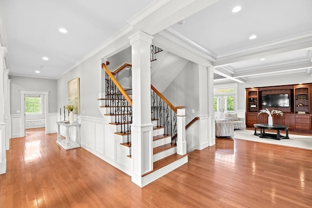 33 Moniz Dr, Westport, MA 02790 - staircase with plenty of natural light, decorative columns, wood finished floors, a decorative wall, and wainscoting