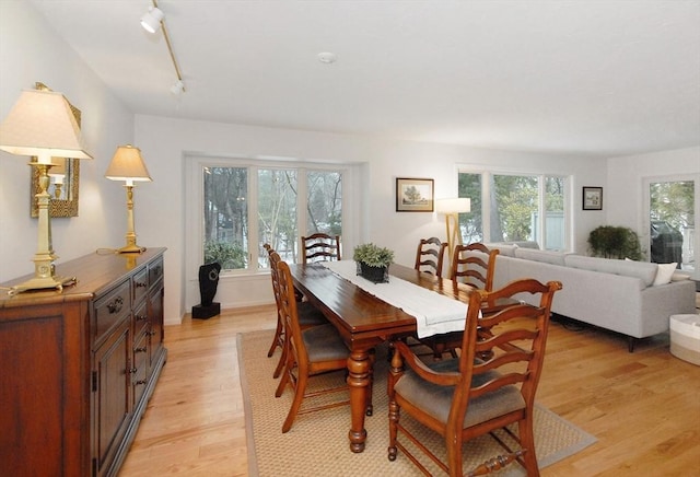 dining room with track lighting and light wood-type flooring