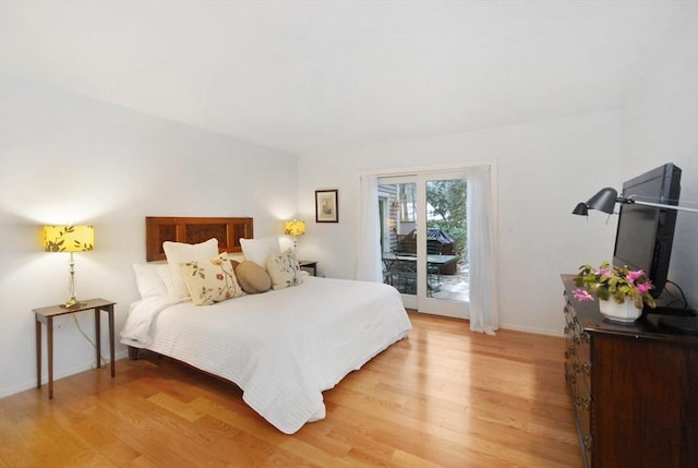 bedroom featuring access to exterior and hardwood / wood-style flooring