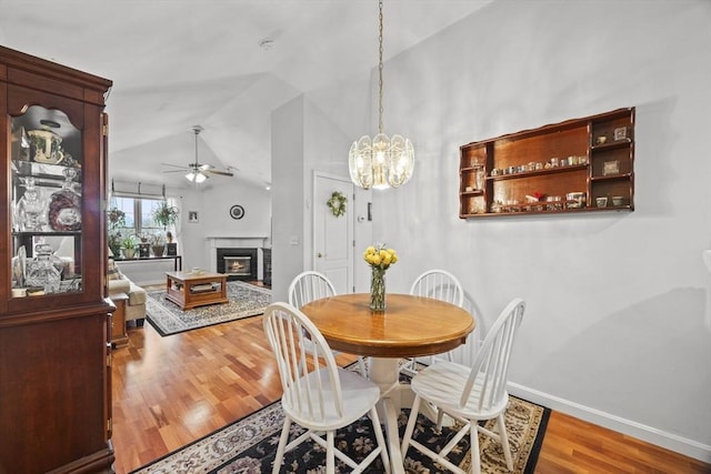 dining area featuring ceiling fan, hardwood / wood-style floors, and lofted ceiling