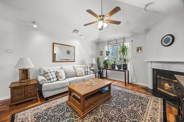 living room with ceiling fan, hardwood / wood-style flooring, track lighting, a fireplace, and lofted ceiling