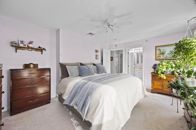 bedroom featuring ceiling fan, ensuite bathroom, and light carpet