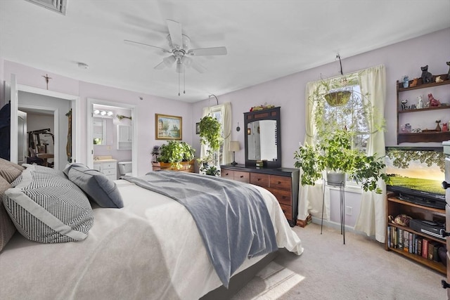 carpeted bedroom featuring connected bathroom and ceiling fan