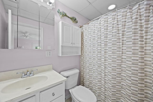 bathroom featuring ceiling fan, toilet, a paneled ceiling, and vanity