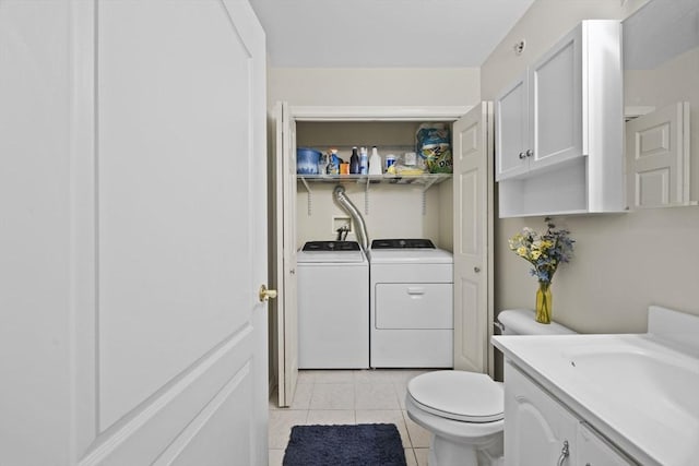 bathroom featuring toilet, tile patterned flooring, vanity, and washing machine and clothes dryer