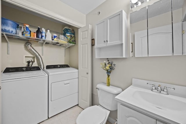 washroom with sink, independent washer and dryer, and light tile patterned floors