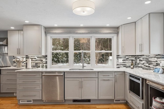 kitchen with light stone countertops, gray cabinets, backsplash, and oven