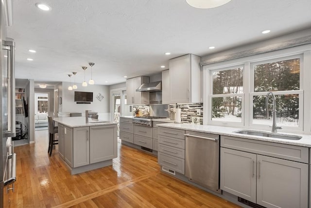 kitchen featuring sink, stainless steel appliances, decorative light fixtures, and gray cabinets