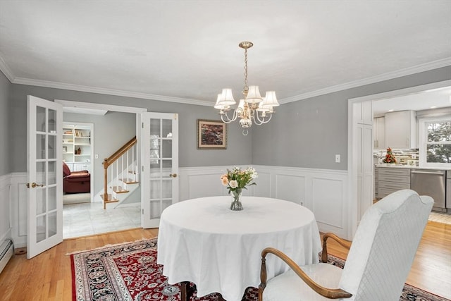 dining space featuring french doors, a chandelier, and crown molding