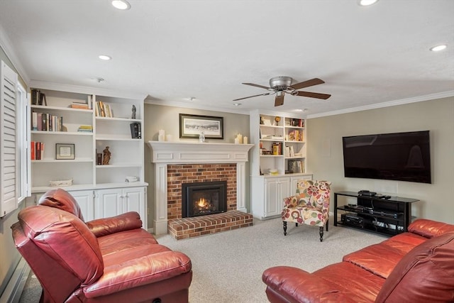 living room with a brick fireplace, light colored carpet, ceiling fan, and crown molding