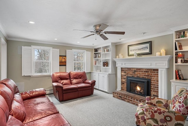 carpeted living room featuring a brick fireplace, a baseboard heating unit, crown molding, built in features, and ceiling fan