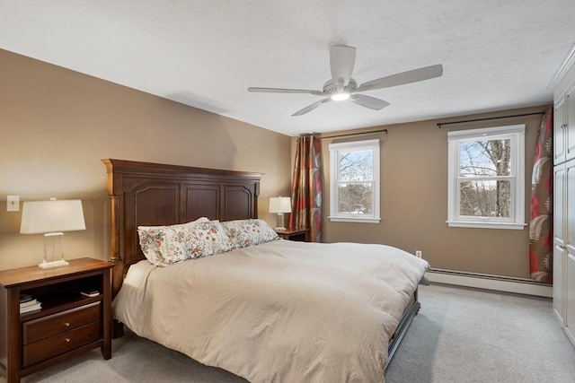 bedroom with ceiling fan, light carpet, and a baseboard heating unit