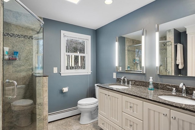 bathroom featuring toilet, vanity, a baseboard heating unit, and a shower with shower door