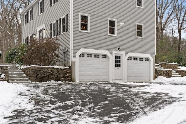 snow covered property with a garage