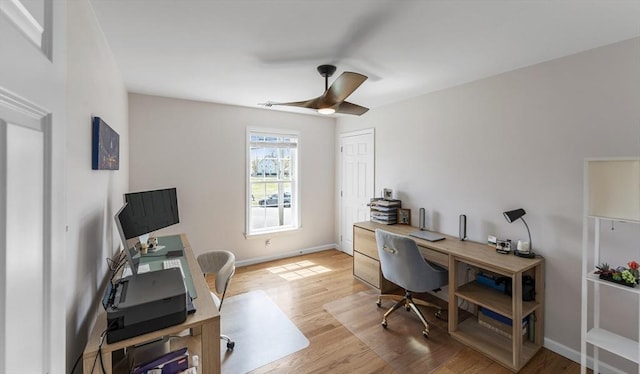office space featuring baseboards, light wood finished floors, and ceiling fan