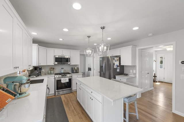kitchen featuring a kitchen island, recessed lighting, appliances with stainless steel finishes, and tasteful backsplash
