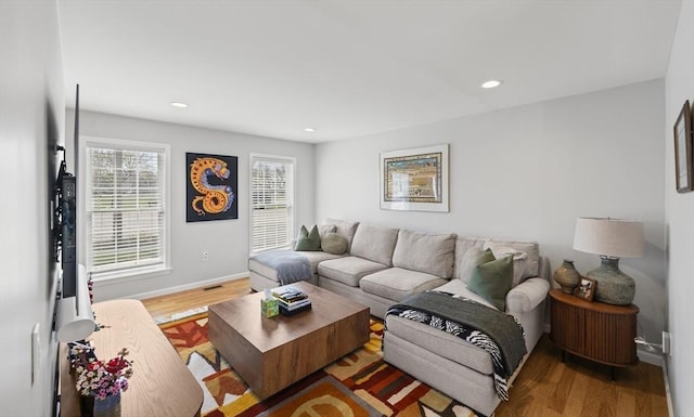 living room featuring recessed lighting, baseboards, and wood finished floors