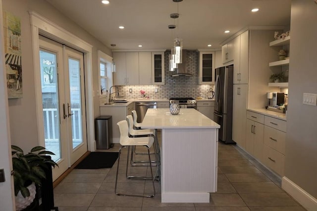 142 Vinal St, Revere, MA 02151 - kitchen featuring stainless steel appliances, wall chimney exhaust hood, tasteful backsplash, light countertops, and a center island