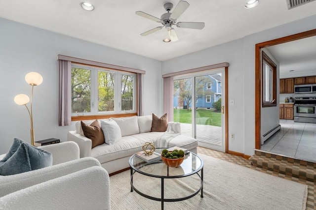 living room featuring a baseboard heating unit, recessed lighting, visible vents, and baseboards