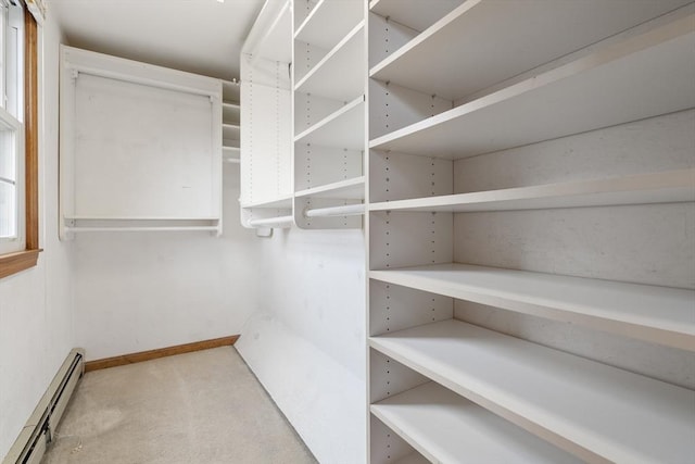 walk in closet featuring baseboard heating and carpet floors