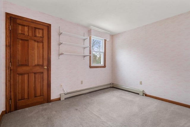 unfurnished room featuring a baseboard heating unit, carpet floors, and baseboards