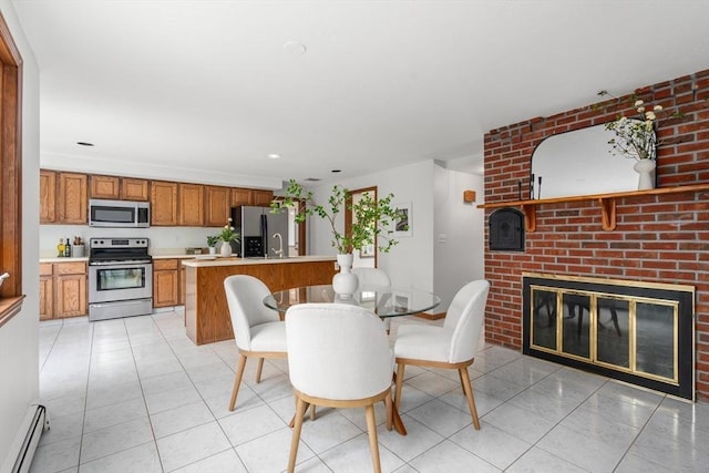 dining room featuring light tile patterned floors, recessed lighting, baseboard heating, and a brick fireplace