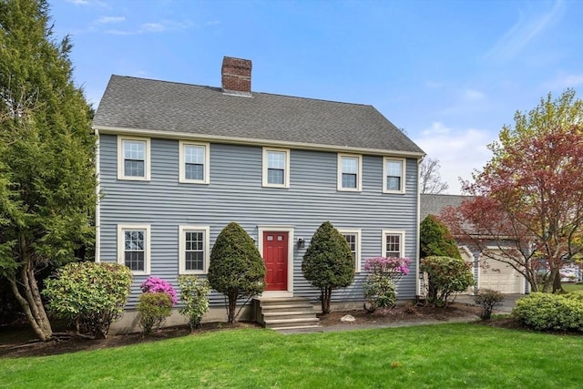 colonial inspired home with a chimney and a front lawn