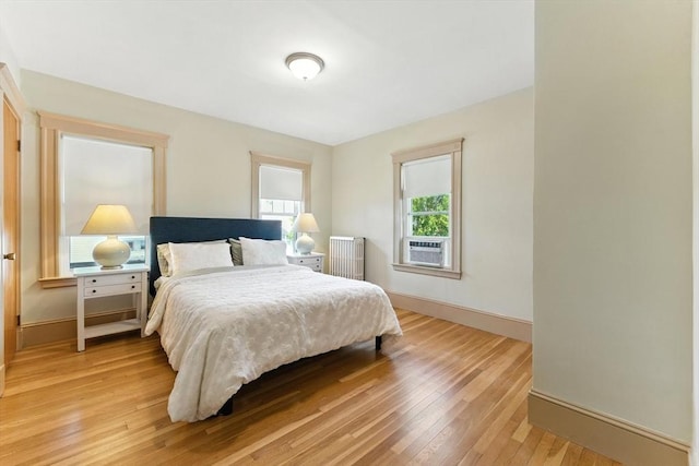 29 Hillcrest Cir Unit 2, Watertown, MA 02472 - bedroom with light wood finished floors, radiator heating unit, and cooling unit