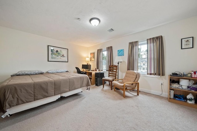 carpeted bedroom featuring baseboards and visible vents