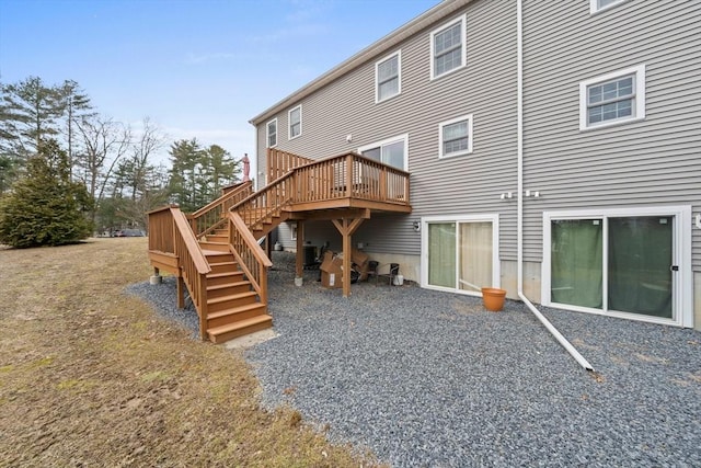 rear view of property featuring stairs and a wooden deck