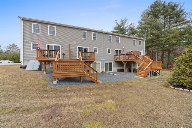 rear view of house featuring stairs and a wooden deck