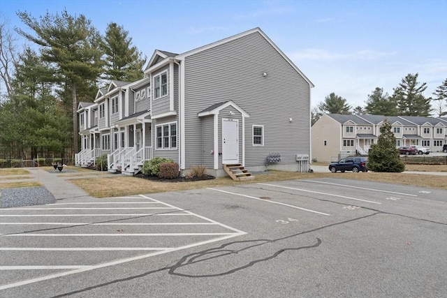 exterior space with entry steps, uncovered parking, and a residential view