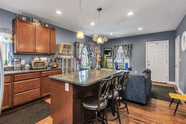 7 S Harlem St, Worcester, MA 01610 - kitchen with a kitchen breakfast bar, wood finished floors, brown cabinetry, a center island, and recessed lighting