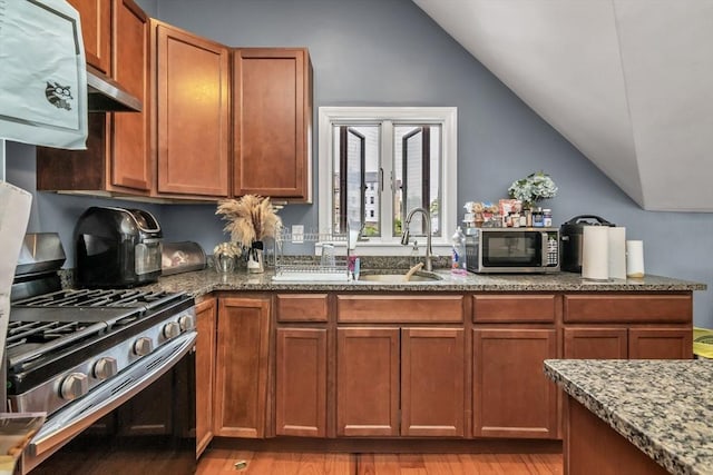 7 S Harlem St, Worcester, MA 01610 - kitchen featuring stainless steel appliances, vaulted ceiling, stone countertops, light wood finished floors, and brown cabinetry
