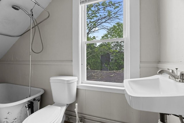 19 Park St, Webster, MA 01570 - full bath featuring a decorative wall, a soaking tub, a sink, toilet, and wainscoting