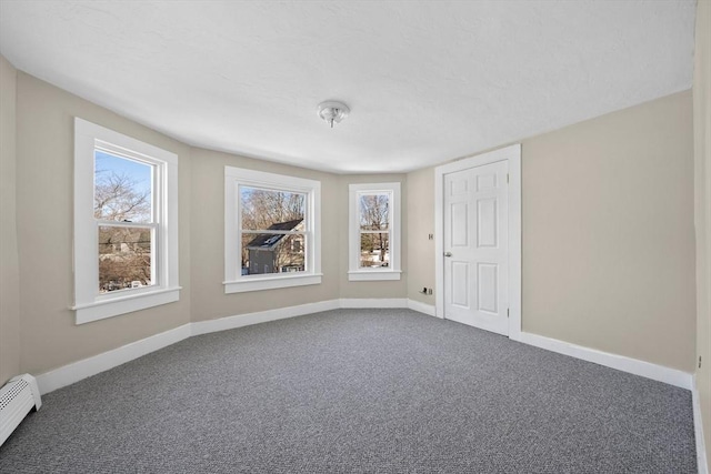 unfurnished room featuring carpet flooring and baseboard heating