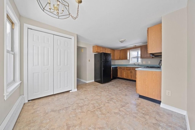 kitchen featuring sink, decorative light fixtures, baseboard heating, a notable chandelier, and black appliances