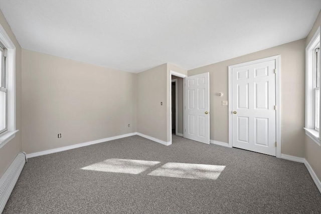 unfurnished bedroom with a baseboard radiator and carpet