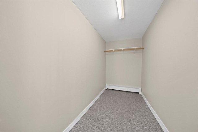 spacious closet with a baseboard radiator and carpet flooring