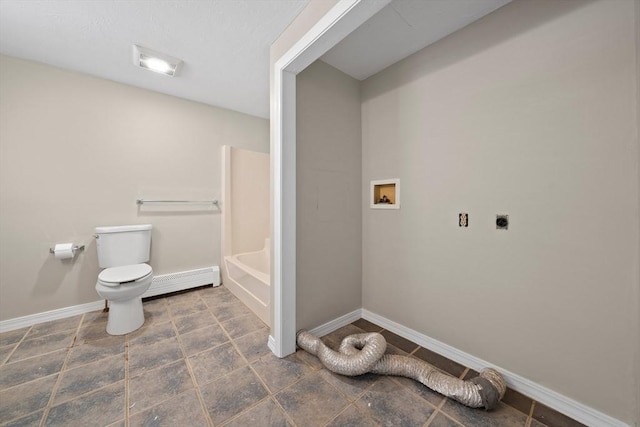 bathroom with a baseboard radiator, toilet, and a tub