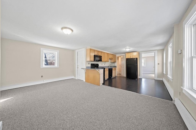 kitchen featuring a baseboard heating unit, a wealth of natural light, light brown cabinets, and black appliances