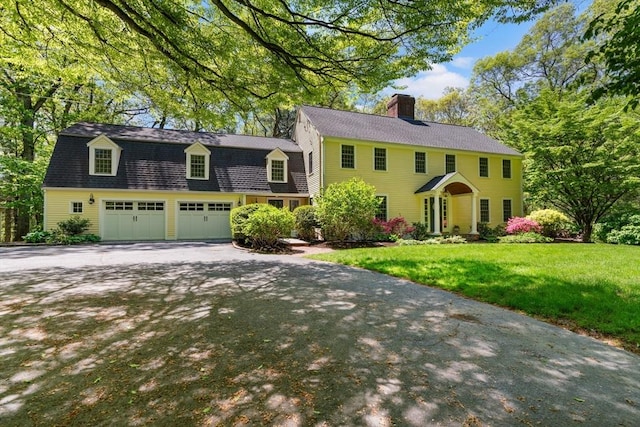 63 Claypit Hill Rd, Wayland, MA 01778 - colonial-style house featuring a chimney, driveway, a front lawn, and a gambrel roof