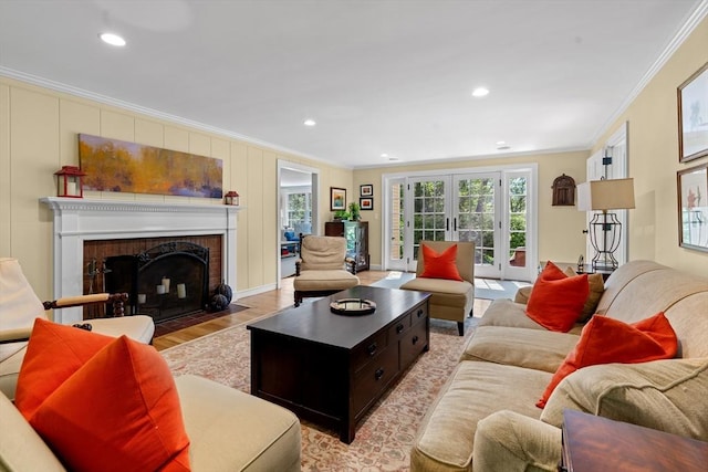 63 Claypit Hill Rd, Wayland, MA 01778 - living room featuring ornamental molding, light wood finished floors, a brick fireplace, recessed lighting, and french doors