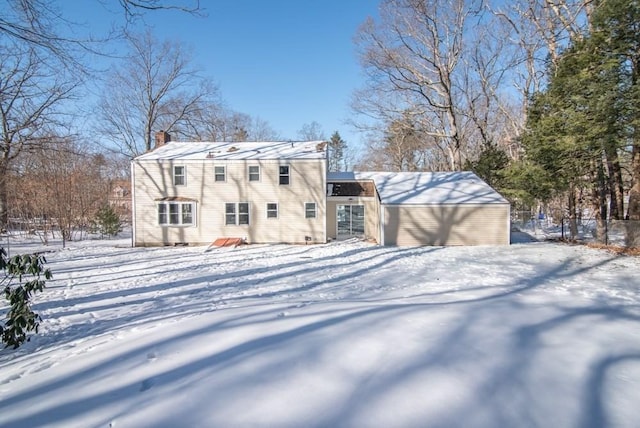 view of snow covered back of property